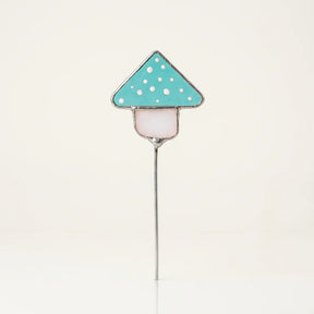 Pflanzenstecker aus hellblauem Glas in Fliegenpilz-Form, gefertigt in Tiffany-Technik mit sichtbaren Kupferfolien-Nähten.