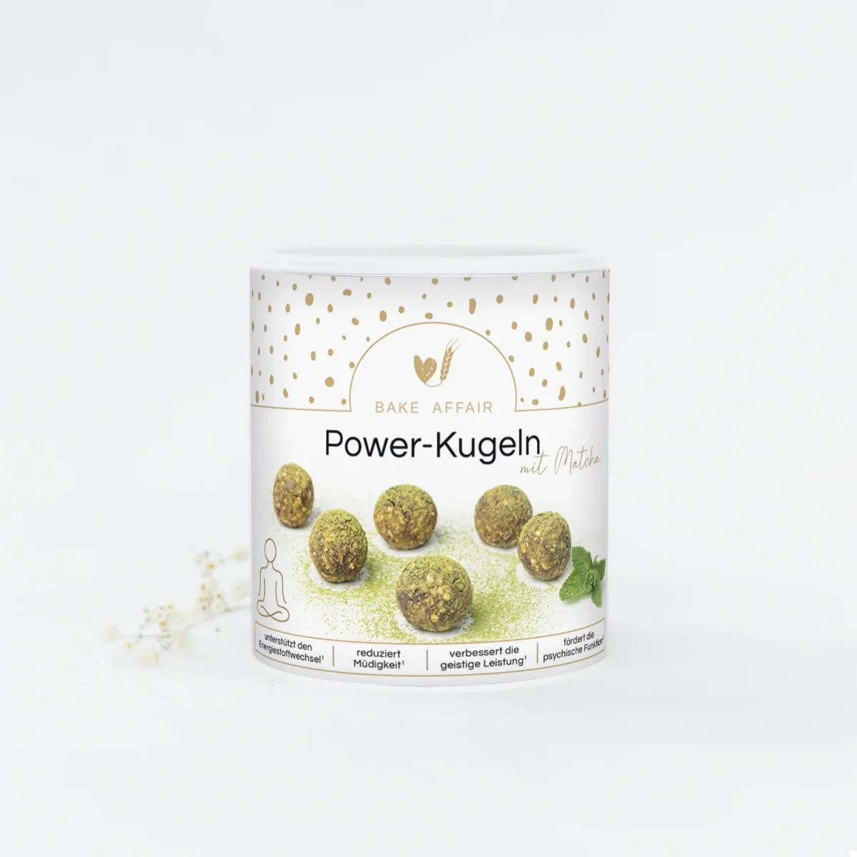 Drei grüne Matcha Power-Kugeln liegen dekorativ neben einer kleinen Schale mit Teepulver.
