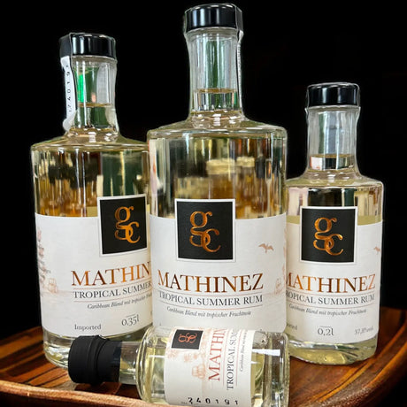 Mathinez Tropical Summer Rum, Flasche mit karibischen Früchten und Palmen im Hintergrund.