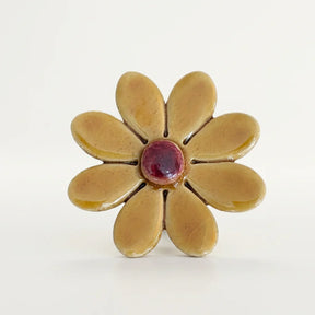 Dunkelgelbes Keramik Gänseblümchen mit einem grünen Metallstiel.