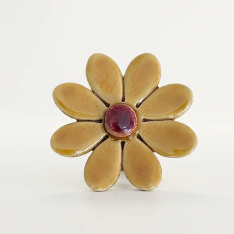 Dunkelgelbes Keramik Gänseblümchen mit einem grünen Metallstiel.