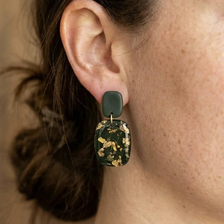 Dunkelgrüne Ohrringe aus Polymer Clay mit goldenen Blattgold-Sprenkeln und weißen Weinsteinkristallen.