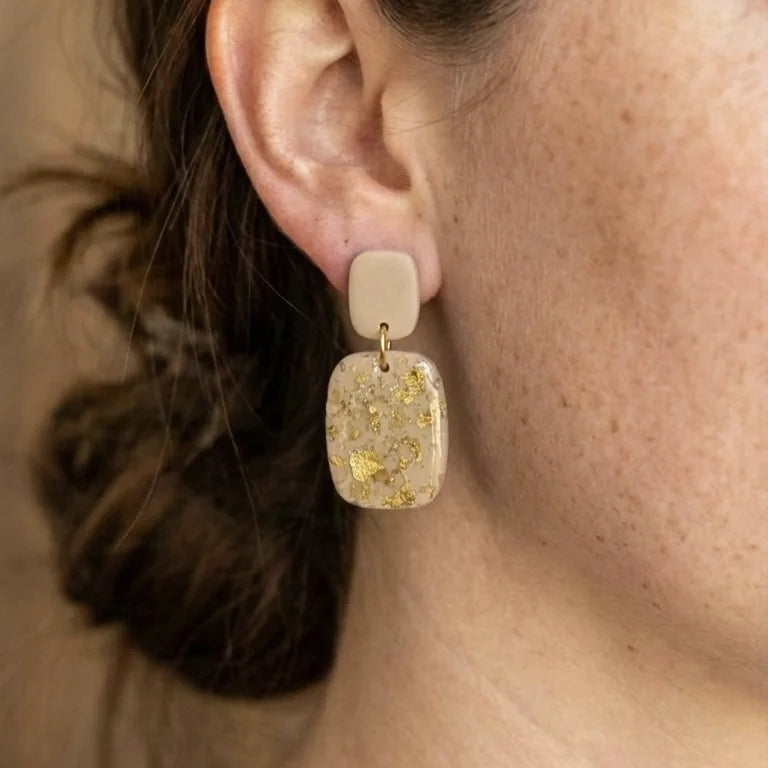 Cremeweiße hängende Ohrringe aus Polymer Clay mit Blattgold-Akzenten und Weinstein-Kristallen.