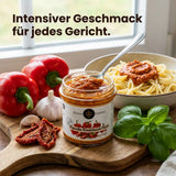 Ein Glas Paprika Knoblauch Pesto mit roter Farbe und sichtbaren Kräutern auf hellem Hintergrund.