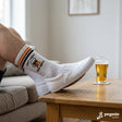 Weiße Sportsocken Baumwolle mit schwarzem Aufdruck „Don't worry, beer happy" auf der Wade, gepolsterte Sohle sichtbar.