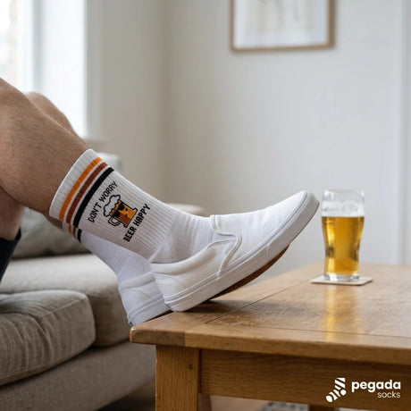 Weiße Sportsocken Baumwolle mit schwarzem Aufdruck „Don't worry, beer happy" auf der Wade, gepolsterte Sohle sichtbar.