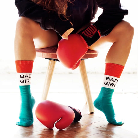 Weiße Sportsocken Damen mit rot-grünen Akzenten und Spruch „Bad Girl" auf der Wade, Baumwoll-Mischgewebe.