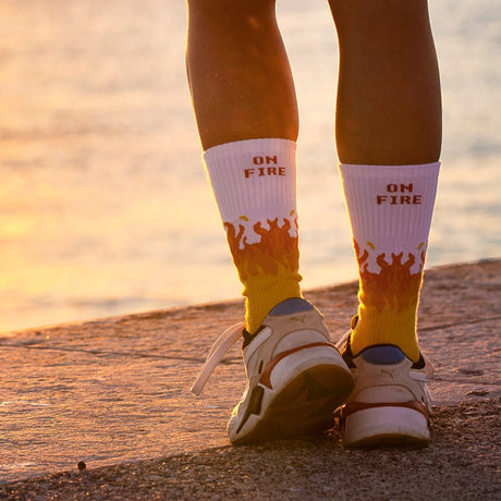 Rote Sportsocken Flammen mit „On Fire"-Schriftzug und Flammendesign auf weißem Hintergrund.