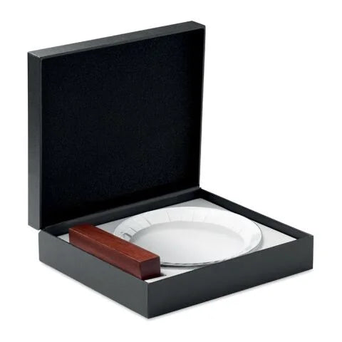 Runder Pokal aus klarem Kristallglas auf einem stabilen Sockel aus hellem Buchenholz vor neutralem Hintergrund