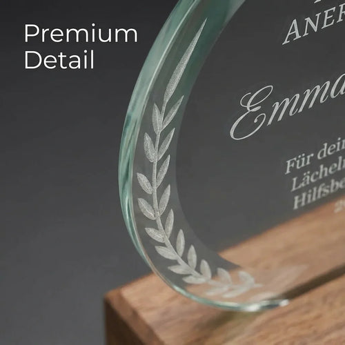 Runder Pokal aus klarem Kristallglas auf einem stabilen Sockel aus hellem Buchenholz vor neutralem Hintergrund