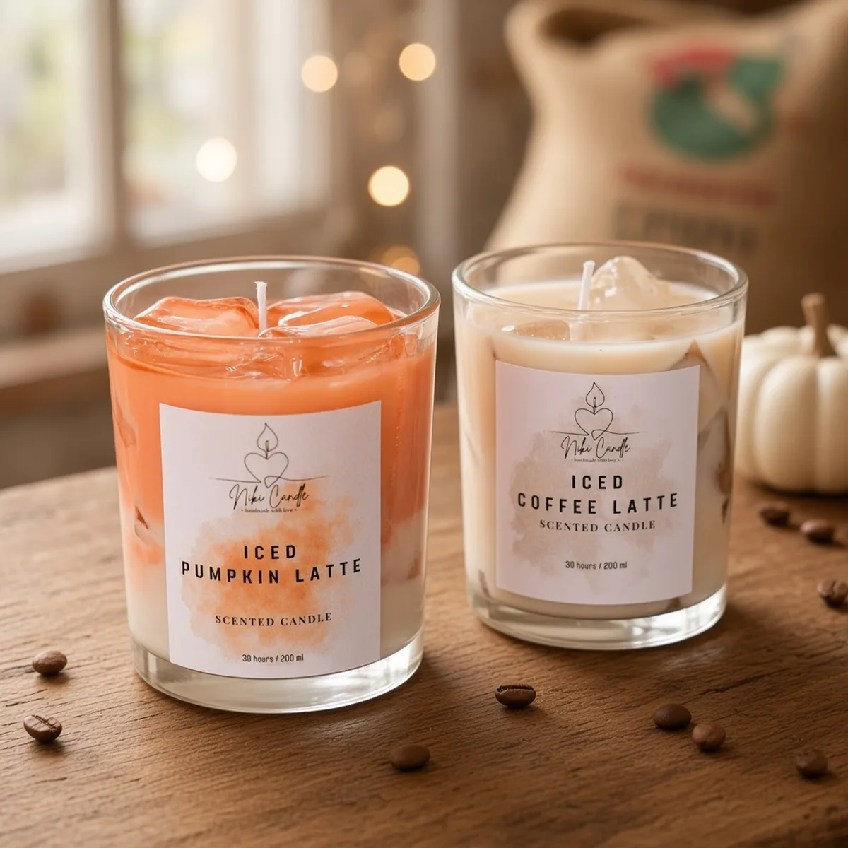 Duftkerzen Iced Pumpkin Latte und Iced Coffee Latte von Niki Candle auf Holz, daneben Kaffeebohnen