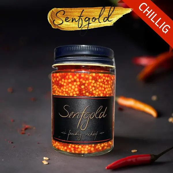 Senfkaviar im Glas mit goldgelben und rötlichen Senfkörnern, daneben rote Chilischoten