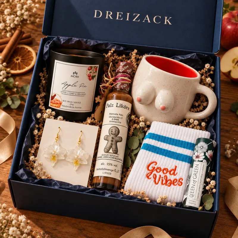 Geöffnete dunkelblaue Dreizack Mystery Box Groß mit Duftkerze Apple Pie, Orchideen-Ohrringen, Lebkuchenlikör, Keramiktasse, Sportsocken „Good Vibes“ und Lippenpflege Sleepy Sophie